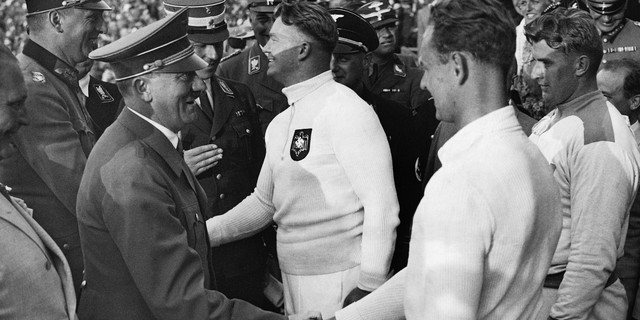 Adolf Hitler (left, foreground) congratulates shot put athletes at the 1936 Berlin Olympics, shaking hands with bronze medal winner Gerhard Stoeck of Germany. Also, from left: Nazi leader Hermann Goering, Kurt Daluege (General of Police), gold medalist Hans Woellke of Germany (center), followed by Hitler's personal adjutant Wilhelm Brueckner (half-covered) and (far right) silver medalist Sulo Baerlund of Finland, on August 2, 1936.