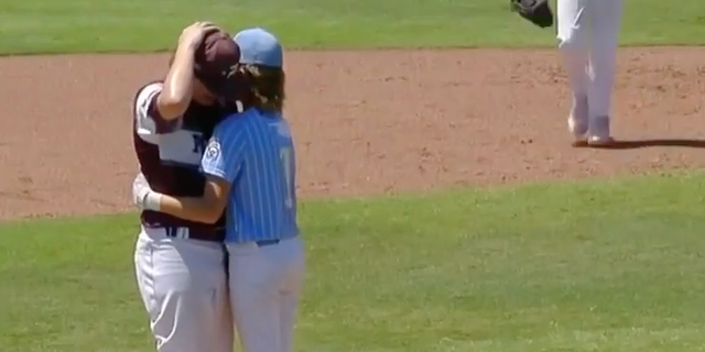 Little Leaguer hitter Isaiah Jarvis and pitcher Kaiden Shelton hug at the pitchers mound after Jarvis was hit in the head by Shelton's pitch.