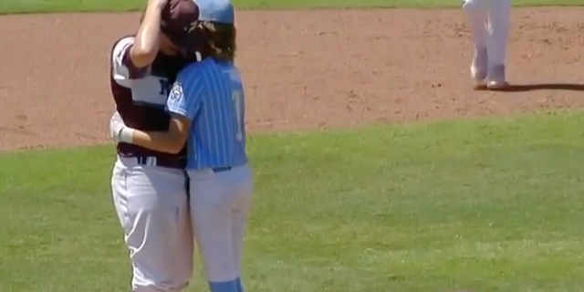 Little Leaguer hitter Isaiah Jarvis and pitcher Kaiden Shelton hug at the pitchers mound after Jarvis was hit in the head by Shelton's pitch.