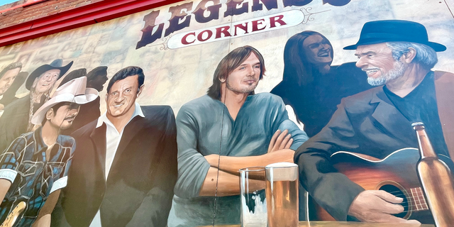 A mural of Music City icons outside Legends Corner, a longtime downtown Nashville honky tonk at the intersection of Broadway and Rep. John Lewis Way North. Pictured (front, from left) are Brad Paisley, Johnny Cash, Keith Urban and Merle Haggard.