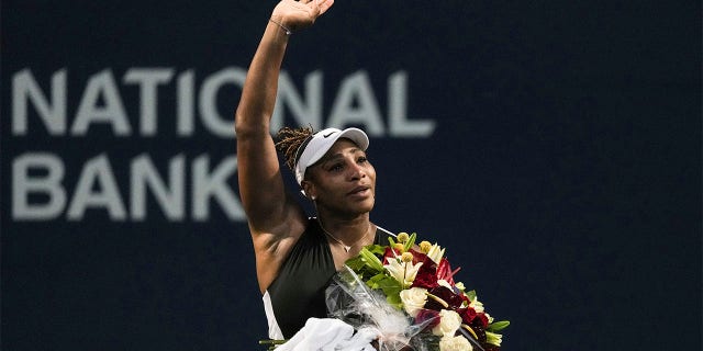 Serena Williams carries flowers and waves to fans after her loss to Belinda Bencic of Switzerland at the National Bank Open tennis tournament in Toronto on August 10, 2022.