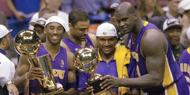 Left to right, Kobe Bryant, Lindsay Hunter and Shaquille O'Neal of the Los Angeles Lakers hold the championship trophy after winning Game 4 of the NBA Finals at Meadowlands, East Rutherford, New Jersey, June 12, 2002. I'm here.