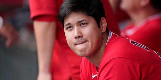 Los Angeles Angels' Shohei Ohtani sits in the dugout during the first inning of a baseball game against the Texas Rangers Sunday, July 31, 2022, in Anaheim, Calif.