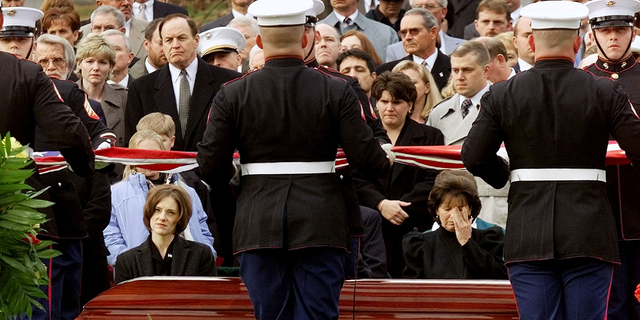 Shannon Spann, seated left, widow of Johnny "Mike" Spann, the CIA officer killed during a violent prison uprising in Afghanistan, and his mother, Gail Spann, seated right, watch an honor guard from the U.S. Marines fold a flag during a funeral ceremony at Arlington National Cemetery, on Dec. 10, 2001.