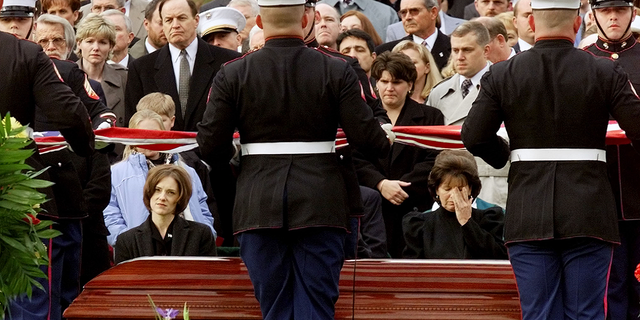 Shannon Spann, seated left, widow of Johnny "Mike" Spann, the CIA officer killed during a violent prison uprising in Afghanistan, and his mother, Gail Spann, seated right, watch an honor guard from the U.S. Marines fold a flag during a funeral ceremony at Arlington National Cemetery, on Dec. 10, 2001.