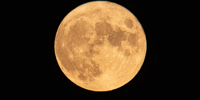 The August Sturgeon full moon rises behind the Hortiatis mountain and Thessaloniki city over the sea, skywatchers call it Blue Moon.
