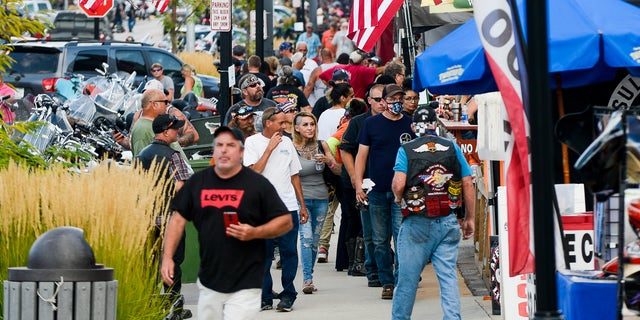 People walk along Main Street lined with American flags, on August 6, 2020, a day before the start of the Sturgis Motorcycle Rally in S.D. 