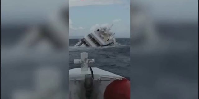 The yacht listing heavily to starboard before submerging underwater.