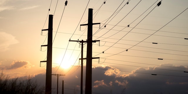 The sun sets behind power transmission lines in Texas.