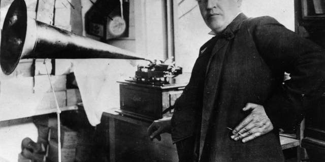 American inventor and businessman Thomas Edison (1847-1931) with an Edison Standard Phonograph, shown at his lab in West Orange, New Jersey, 1906. The Edison Standard Phonograph, a wax cylinder player, shown here with its sound horn supported on a tripod, was produced from 1898 to 1913.