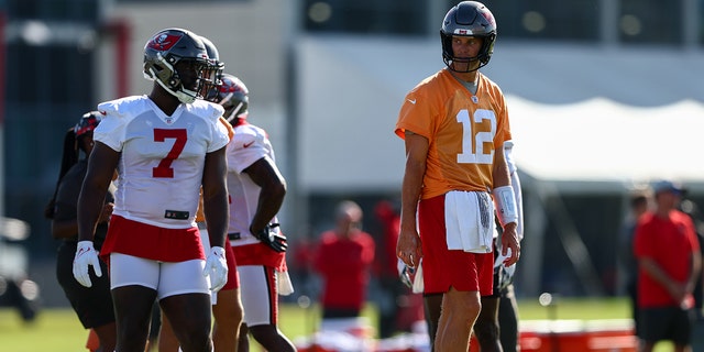 Tampa Bay Buccaneers quarterback Tom Brady (12) and running back Leonard Fournette (7) participate in training camp at AdventHealth Training Center in Tampa, Florida, on July 30, 2022.