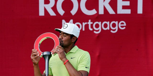 Tony Finau kisses the winner's trophy after the final round of the Rocket Mortgage Classic golf tournament, Sunday, July 31, 2022, in Detroit.