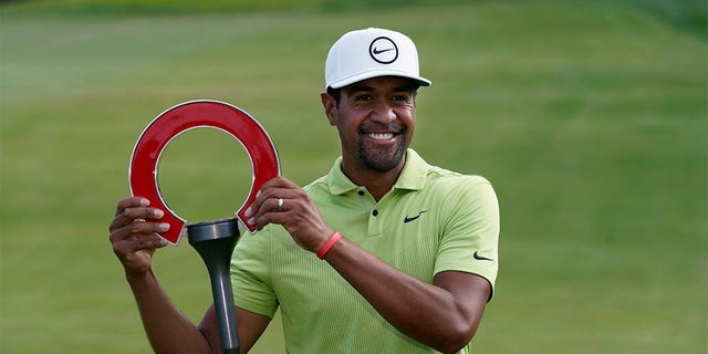 Tony Finau holds the winner's trophy after the final round of the Rocket Mortgage Classic golf tournament, Sunday, July 31, 2022, in Detroit. 