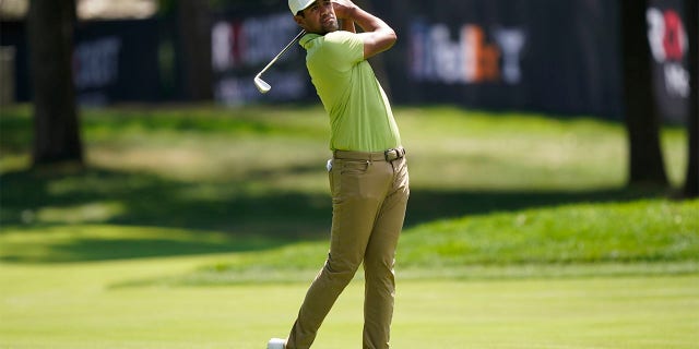 Tony Finau hits his second shot onto the seventh green during the final round of the Rocket Mortgage Classic golf tournament, Sunday, July 31, 2022, in Detroit.