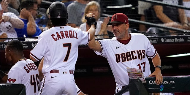 Arizona Diamondbacks' manager Torey Lovullo high fives Arizona Diamondbacks' Corbin Carroll (7) during the fourth inning of a baseball game, Monday, Aug. 29, 2022, in Phoenix.