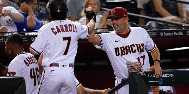 Arizona Diamondbacks' manager Torey Lovullo high fives Arizona Diamondbacks' Corbin Carroll (7) during the fourth inning of a baseball game, Monday, Aug. 29, 2022, in Phoenix.