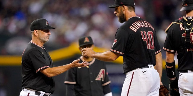 Arizona Diamondbacks starting pitcher Madison Bumgarner (40) is pulled from the game by manager Torey Lovullo, left, during the sixth inning of a baseball game against the St. Louis Cardinals, Saturday, Aug. 20, 2022, in Phoenix.