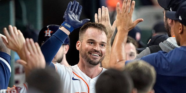 Houston Astros' Trey Mancini celebrates with teammates in the dugout after hitting a two-run home run against the Boston Red Sox during the second inning of a baseball game Wednesday, Aug. 3, 2022, in Houston. 