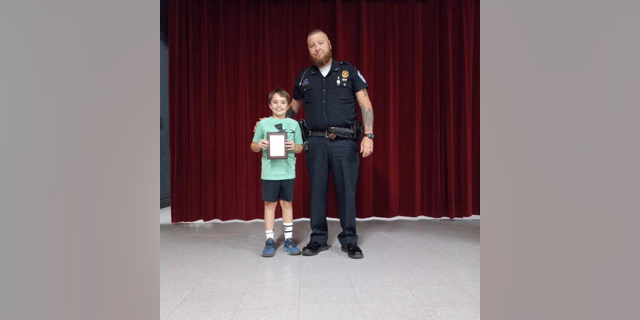 10-year-old Gavin was awarded by the Kingston Police Department in Oklahoma for his actions in saving his mother.