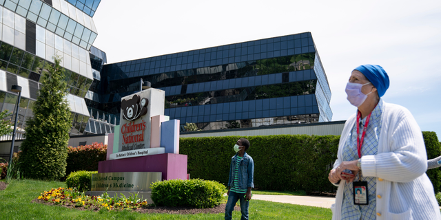 Registered nurse Jean Boone watches from Children's National Hospital as the U.S. Navy Blue Angels and U.S. Airforce Thunderbirds fly over the D.C. area on May 2, 2020 in Washington, DC. 