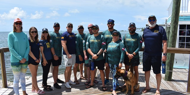 Military veterans pose with the Force Blue team at a dive mission in Islamorada, Florida, in June 2022.