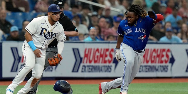 Toronto Blue Jays' Vladimir Guerrero Jr., right, steals third base as Tampa Bay Rays third baseman Isaac Paredes fields a wide throw during the third inning of a baseball game Tuesday, Aug. 2, 2022, in St. Petersburg, Fla.