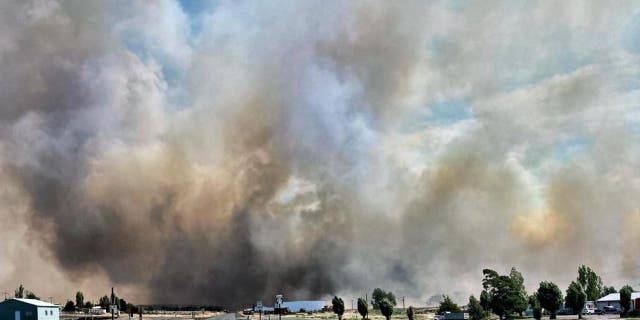 This photo provided by the Washington State Department of Transportation shows smoke from a wildfire burning Thursday, Aug. 4, 2022. Sheriff's officials are telling residents in the town of Lind in eastern Washington to evacuate because of a growing wildfire south of town that was burning homes.