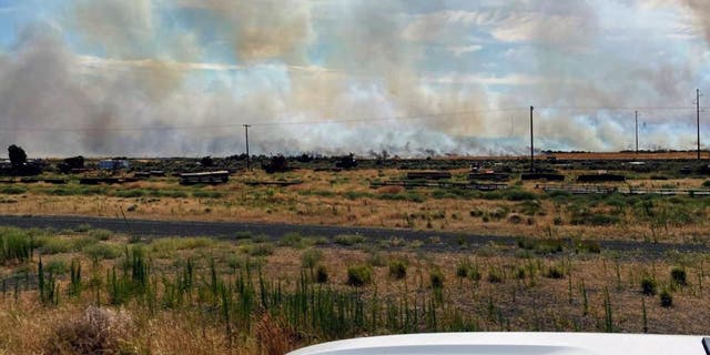 This photo provided by the Washington State Department of Transportation shows smoke from a wildfire burning on Thursday, Aug. 4, 2022. Sheriff's officials are telling residents in the town of Lind in eastern Washington to evacuate because of a growing wildfire south of town that was burning homes. 
