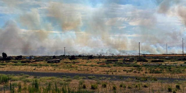 This photo provided by the Washington State Department of Transportation shows smoke from a wildfire burning on Thursday, Aug. 4, 2022. Sheriff's officials are telling residents in the town of Lind in eastern Washington to evacuate because of a growing wildfire south of town that was burning homes.
