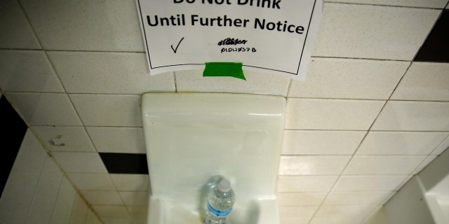 A sign is seen next to a water dispenser at North Western High School in Flint, a city struggling with the effects of lead-poisoned drinking water in Michigan, May 4, 2016. 