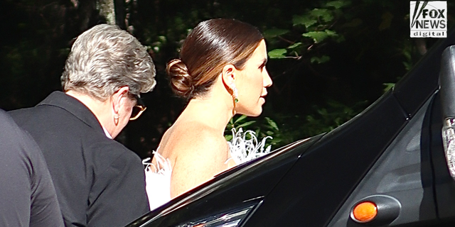 A woman in white arrives at Ben Affleck and Jennifer Lopez's wedding venue.