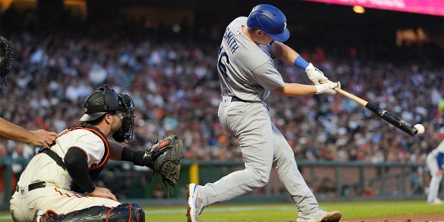 Los Angeles Dodgers' Will Smith, right, hits an RBI double in front of San Francisco Giants catcher Joey Bart during the fifth inning of a baseball game in San Francisco, Monday, Aug. 1, 2022.