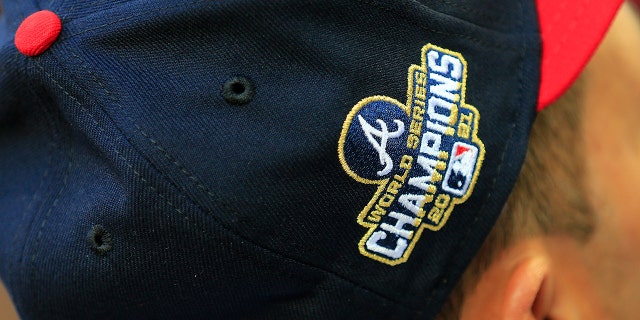The logo of the 2021 World Series champions embroidered in gold is displayed on the cap of an Atlanta Braves uniform April 7, 2022 at Truist Park in Atlanta, Georgia.