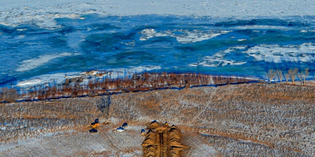 FILE - This Jan. 19, 2015 file photo crews work to contain an oil spill from Bridger Pipeline's broken pipeline near Glendive, Montana, in this aerial view showing both sides of the river.