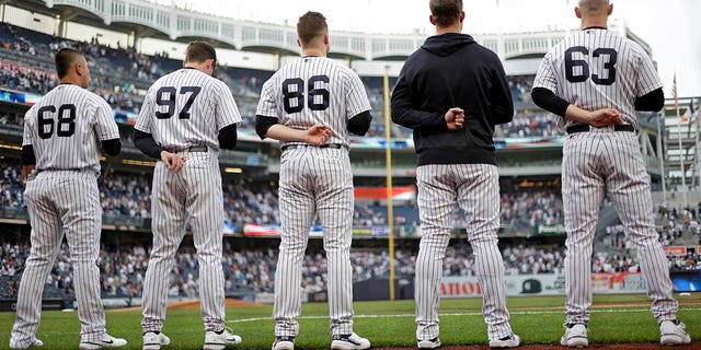 Manny Bañuelos #68 de los New York Yankees, Ron Marinaccio #97 de los New York Yankees, Clarke Schmidt #86 de los New York Yankees, Lucas Luetge #63 de los New York Yankees defienden el himno nacional antes de enfrentar a los Tigres de Detroit en Yankee Stadium el 3 de junio de 2022 en la ciudad de Nueva York.