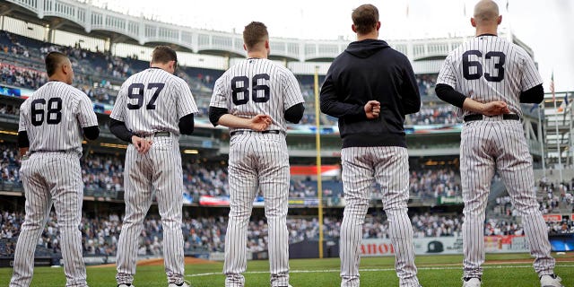 Manny Banuelos #68 of the New York Yankees, Ron Marinaccio #97 of the New York Yankees, Clarke Schmidt #86 of the New York Yankees, Lucas Luetge #63 of the New York Yankees stand for the national anthem before taking on the Detroit Tigers at Yankee Stadium on June 3, 2022 in New York City.