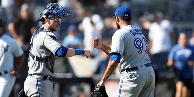 Toronto Blue Jays catcher Danny Jansen and relief pitcher Yimi Garcia celebrate after defeating the Yankees, Saturday, Aug. 20, 2022, in New York.