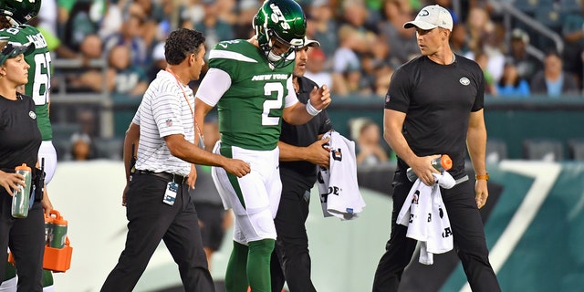 New York Jets quarterback Zach Wilson (2) is helped off the field against the Philadelphia Eagles during the first quarter at Lincoln Financial Field in Philadelphia Aug. 12, 2022.