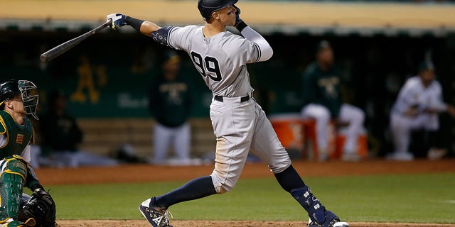 Aaron Judge #99 of the New York Yankees hits a three-run home run in the top of the fifth inning against the Oakland Athletics at RingCentral Coliseum on August 26, 2022, in Oakland, California.