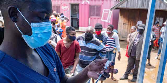 A man in Johannesburg administers doses of the COVID-19 vaccine in South Africa on December 8, 2021. Demand for vaccines in South Africa is extremely low, resulting in the country's Aspen Pharmacare shutting down vaccine manufacturing.