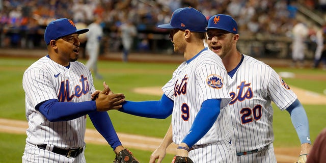 #10 Eduardo Escobar and #20 Pete Alonso of the New York Mets congratulate teammate Brandon Nimmo #9 after the seventh inning against the Los Angeles Dodgers at City Field on August 31, 2022 in New York City.  Nimmo hit a halftime saving home run.