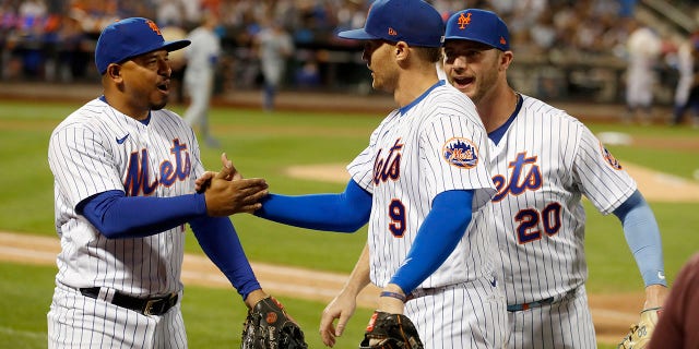 Eduardo Escobar #10 and Pete Alonso #20 of the New York Mets congratulate teammate Brandon Nimmo #9 after the seventh inning against the Los Angeles Dodgers at Citi Field on August 31, 2022 in New York City. Nimmo made a home-run saving catch in the inning.