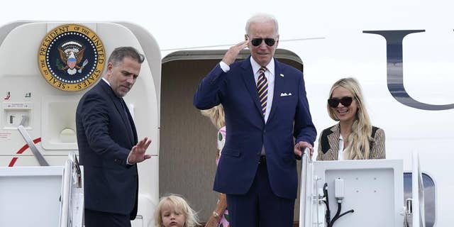 President Joe Biden, center, returns a salute as he is joined by, from left, son Hunter Biden, grandson Beau Biden, first lady Jill Biden, obscured, and daughter-in-law Melissa Cohen, as they stand at the top of the steps of Air Force One.