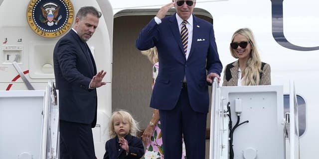 President Joe Biden, center, returns a salute as he is joined by, from left, son Hunter Biden, grandson Beau Biden, first lady Jill Biden, obscured, and daughter-in-law Melissa Cohen, as they stand at the top of the steps of Air Force One.