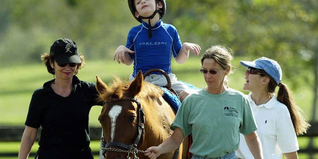 A boy with cerebral palsy partakes in equine therapy on Nov. 19, 2003 in Coconut Creek, Florida. A nonprofit program is making equine therapy available to children with cerebral palsy of low-income families in Venezuela.