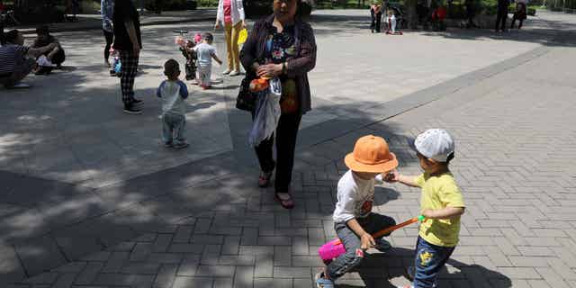 Beijing is taking steps to boost fertility in the country as China's fertility rate plummets below the OECD's standard for a stable population. Pictured: Children play in a park in Beijing on June 1, 2021.