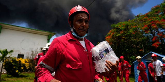 Des membres de la Croix-Rouge cubaine se préparent à se rendre à la base de Matanzas Supertanker, où les pompiers travaillent pour éteindre un incendie qui s'est déclaré lors d'un orage la nuit précédente, à Matanzas, Cuba, le 6 août 2022 (AP Photo/Ramon Espinosa)