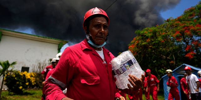 Des membres de la Croix-Rouge cubaine se préparent à se rendre à la base de Matanzas Supertanker, où les pompiers travaillent pour éteindre un incendie qui s'est déclaré lors d'un orage la nuit précédente, à Matanzas, Cuba, le 6 août 2022 (AP Photo/Ramon Espinosa)