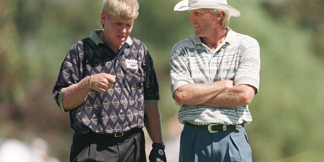 Golfers Greg Norman of Australia and John Daly of the US strike up a conversation while on the 11th hole during the first round of the 1996 Heineken Classic at Vines Resort in Perth, Australia.