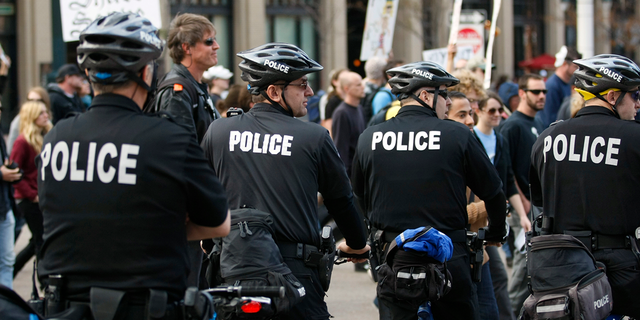 Police watch an Occupy Denver protest march through downtown Denver on Nov. 5, 2011.